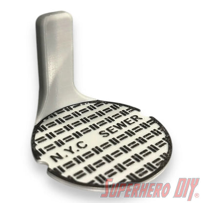 Floating shelf designed to display TMNT action figures and collectibles, styled like a sewer manhole cover for themed wall display