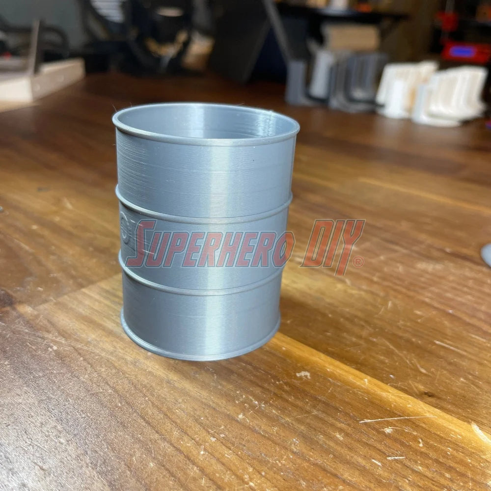 Mini oil drum desk organizer on wooden table, 3D-printed plastic design, perfect for small storage or a unique gag gift.