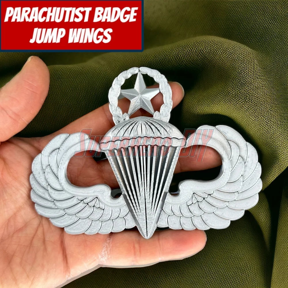 Jump Wings Parachutist Badge held in hand against green fabric