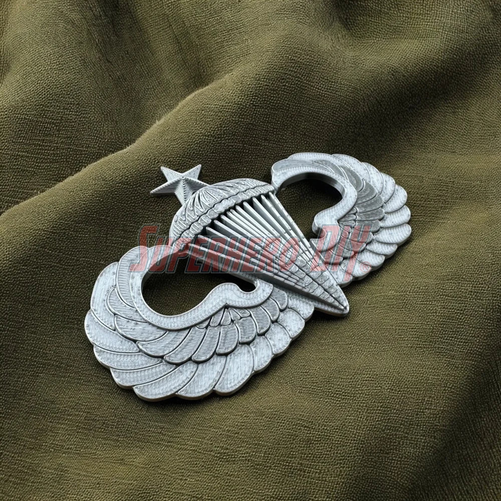 Jump Wings badge on olive drab fabric, symbolizing military parachutist achievements with detailed wing and star design.