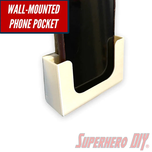 Wall-mounted phone holder with phone displayed, featuring a sleek white design, ideal for hands-free convenience in bathroom or office spaces.
