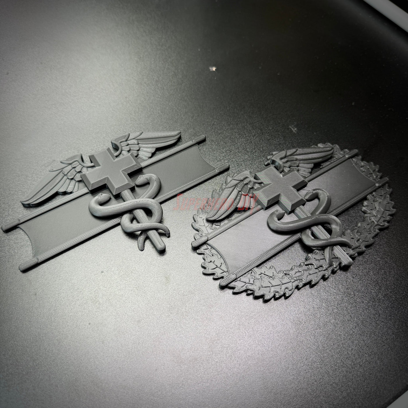 Army medical badge display featuring the EFMB and CMB insignia in detailed design.