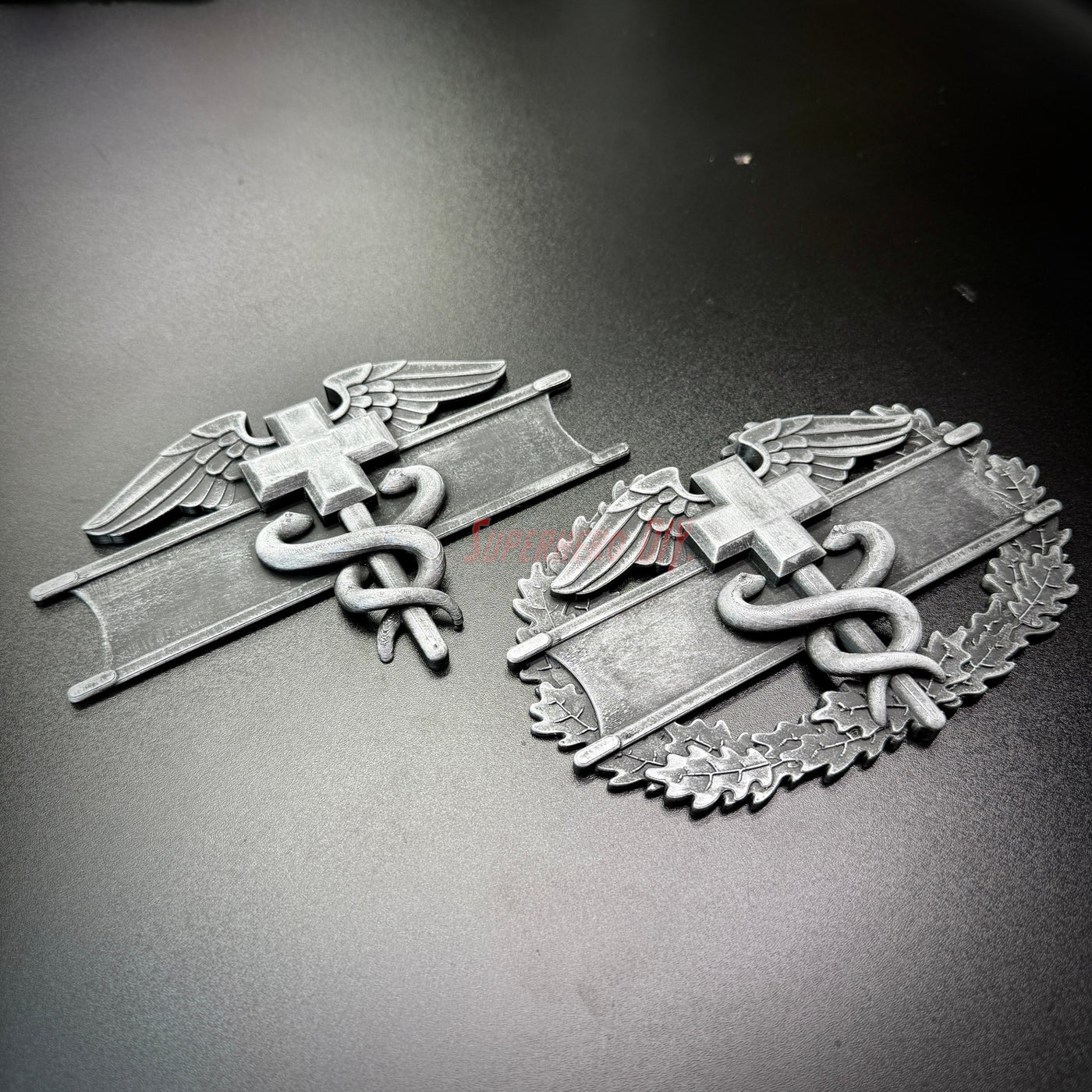 Army medical badge display featuring the Expert Field Medical Badge and Combat Medical Badge in detailed design.