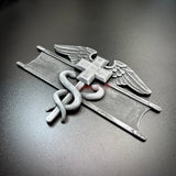 Army medical badge display showing a Combat Medical Badge with caduceus and Geneva Convention cross detail.