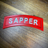 3D sapper tab displayed on wooden background, highlighting the achievement of combat engineers.