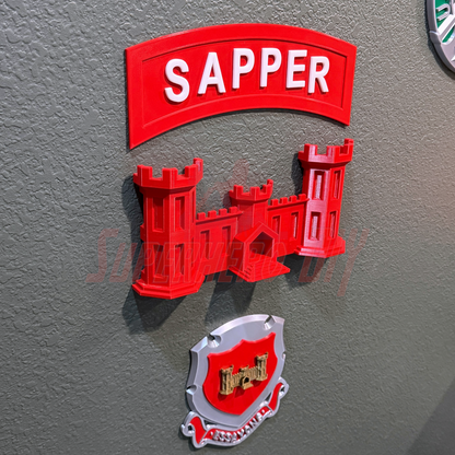 3D sapper tab display piece featuring a red 'SAPPER' sign and castle design on a wall.