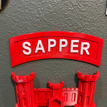 3D sapper tab display piece featuring the word 'SAPPER' in bold red letters on a wall.