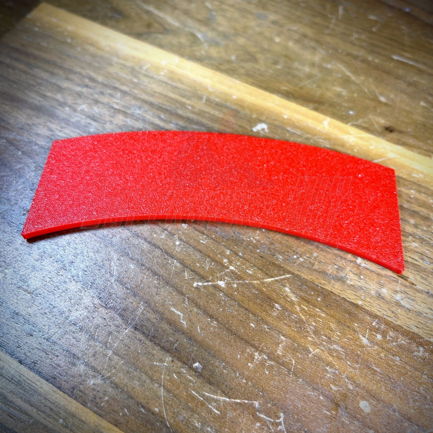 3D sapper tab in vibrant red color displayed on wooden surface.