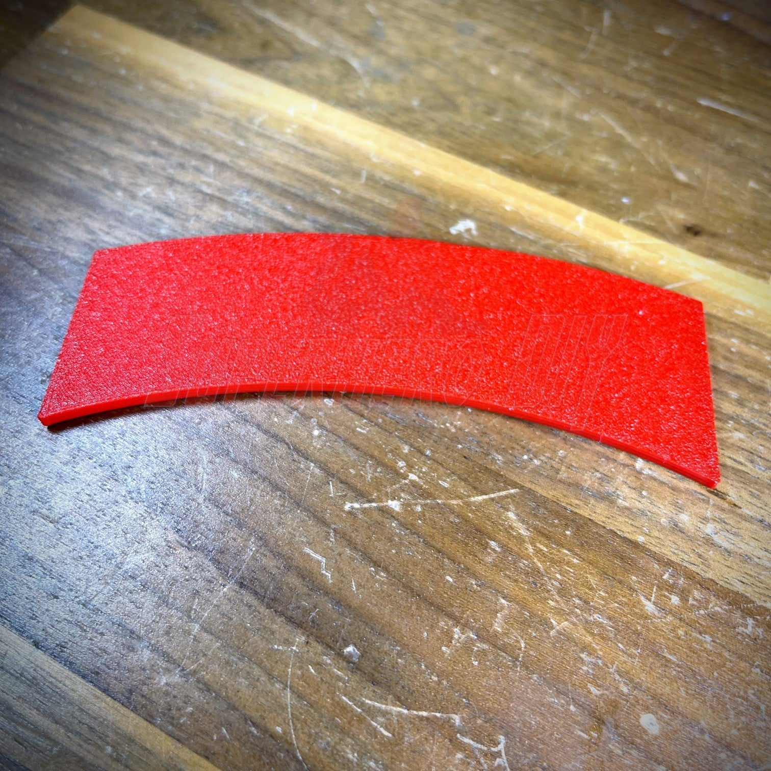 3D sapper tab in vibrant red color displayed on wooden surface.