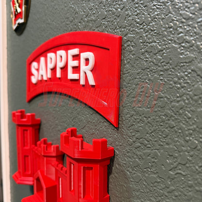 Close-up of a 3D sapper tab displayed on a wall, highlighting the red 'SAPPER' lettering.