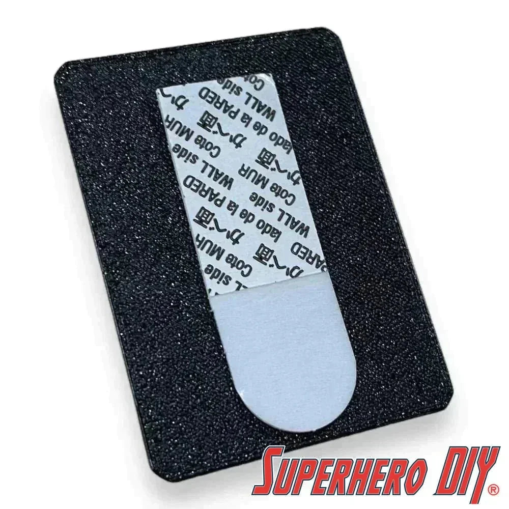 Blister pack wall hanger with Command Strip for damage-free mounting of action figures and collectibles.