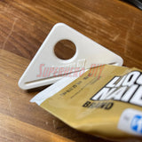 Simple Tube Squeezer shown with a tube of Liquid Nails on a wooden surface.