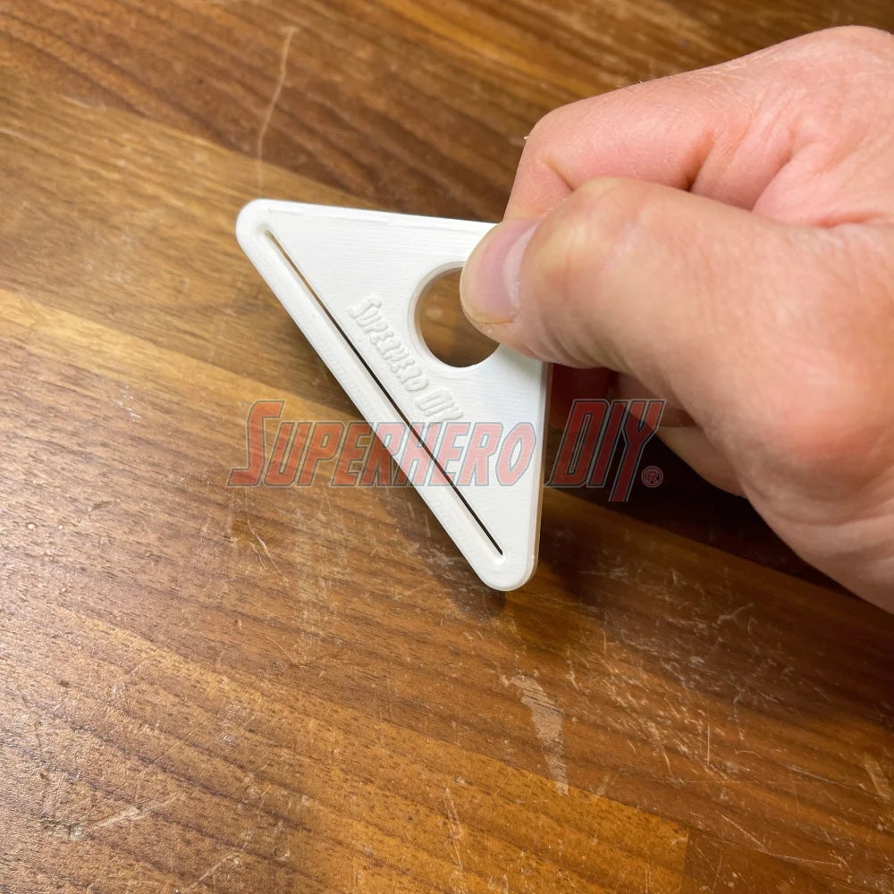 Simple Tube Squeezer being used to extract product from a toothpaste tube on a wooden surface.