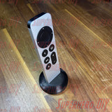 Apple TV Remote Stand holding Apple TV Siri Remote upright on wooden surface