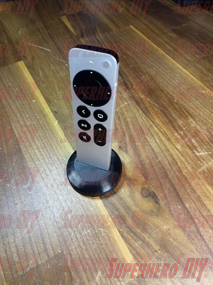 Apple TV Remote Stand holding Siri Remote upright on a wooden surface