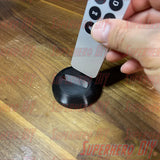 Apple TV Remote Stand holding Siri Remote upright on wooden table