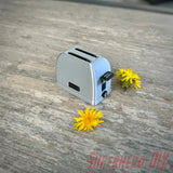 Mini toaster-shaped SD card holder that stores 2 memory cards and doubles as a fun desktop fidget