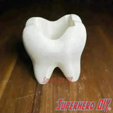 Tooth shaped bathroom organizer with unique tooth cup toothbrush holder for a fun and functional bathroom decor.