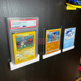 Trading card wall mounts showcasing PSA graded slabs with Pokémon cards.