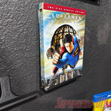 Floating shelf for movies or video games displaying Superman Returns DVD cover with command strip attachment on a wall.