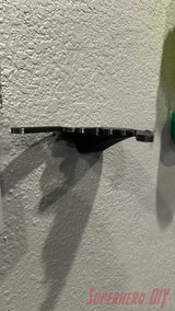 Black wall mount shelf designed to hold Funko POP! Dragon rides, floating style on textured wall. - SuperheroDIY