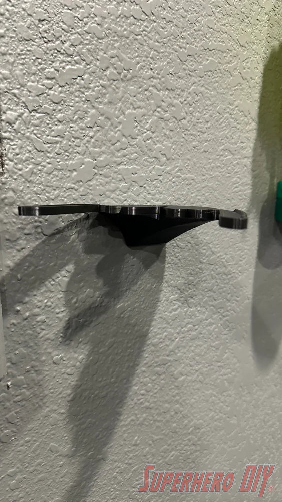 Black wall mount shelf designed to hold Funko POP! Dragon rides, floating style on textured wall. - SuperheroDIY