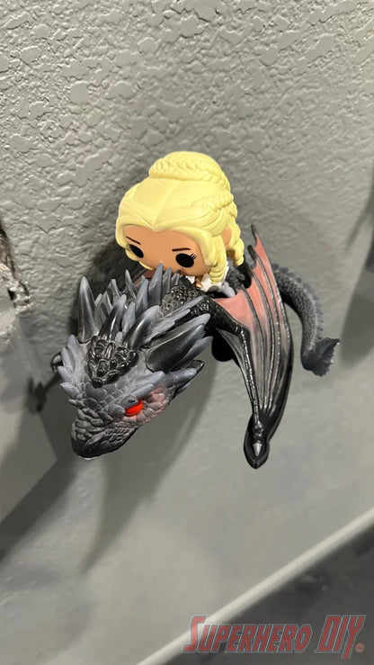 Black wall mount shaped like a Menacing dragon head holding a Funko Pop figure of a blonde woman riding it. - SuperheroDIY