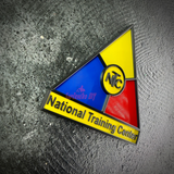 National Training Center insignia display tilted on gray concrete, raised NTC monogram in the center ring