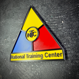 Angled close view of the National Training Center display insignia, blue and red panels around the NTC ring
