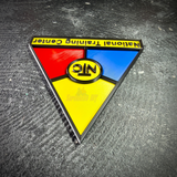 NTC wall display insignia upside down on concrete, showing the raised edges on every color panel