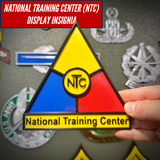 National Training Center (NTC) display insignia held in hand in front of a wall of military insignia displays