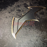 3D-printed plastic BvS JL batarang prop in black and gold, perfect for cosplay and costume accessories.