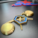 Chemical Corps insignia displayed on a dark surface, featuring a cobalt blue benzene ring and crossed gold retorts.