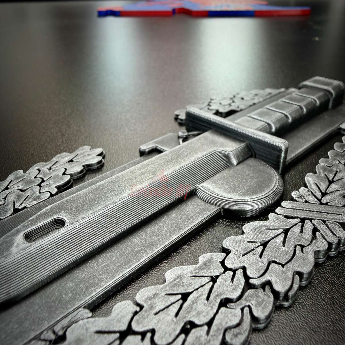 Combat Action Badge display featuring detailed bayonet and oak wreath design on a black surface.