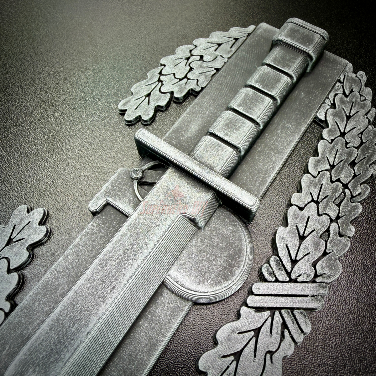 Close-up of a Combat Action Badge display insignia featuring a bayonet and oak wreath.