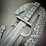 Close-up of a Combat Action Badge display insignia featuring a bayonet and oak wreath.
