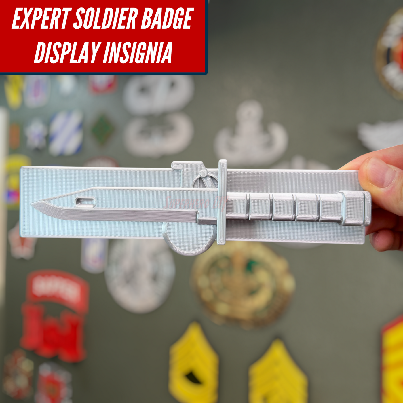 Expert Soldier Badge display insignia shown in silver on a wall with various military patches in the background.