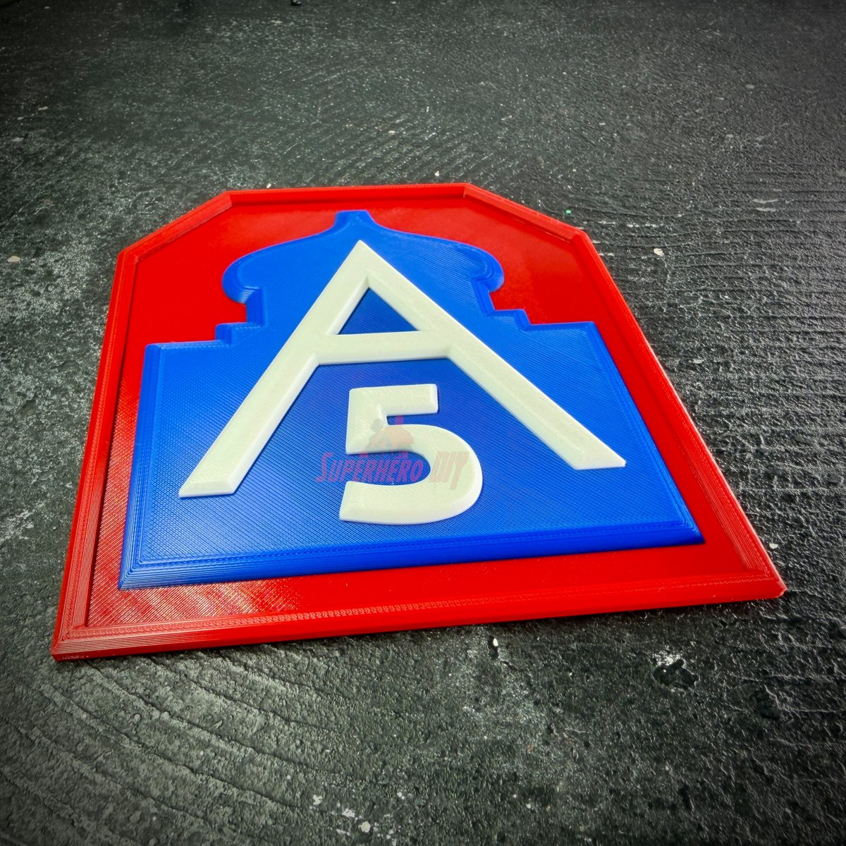 Low angle of the Fifth Army insignia display on dark stone, showing the depth of the red border and blue mosque