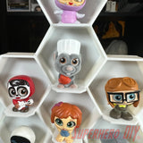 Honeycomb Wall Display for Disney Doorables: Organize and Showcase Your Collection with colorful figures displayed in white hexagonal shelves.