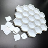 3D-printed honeycomb display for 19 Disney Doorables, showcasing empty hexagonal slots on a black surface.
