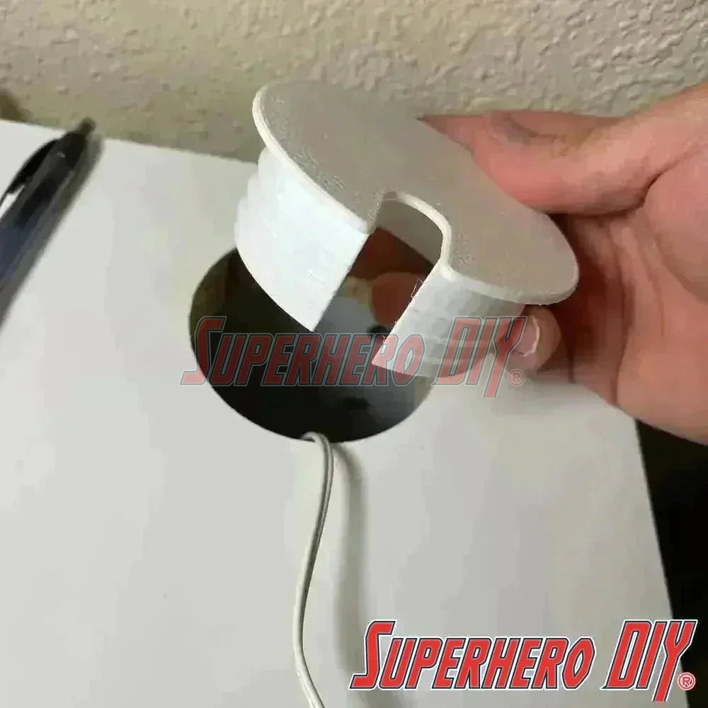 White IKEA MICKE desk hole cover being placed into desk wiring hole, compatible with the IKEA MICKE desk for a tidy setup.