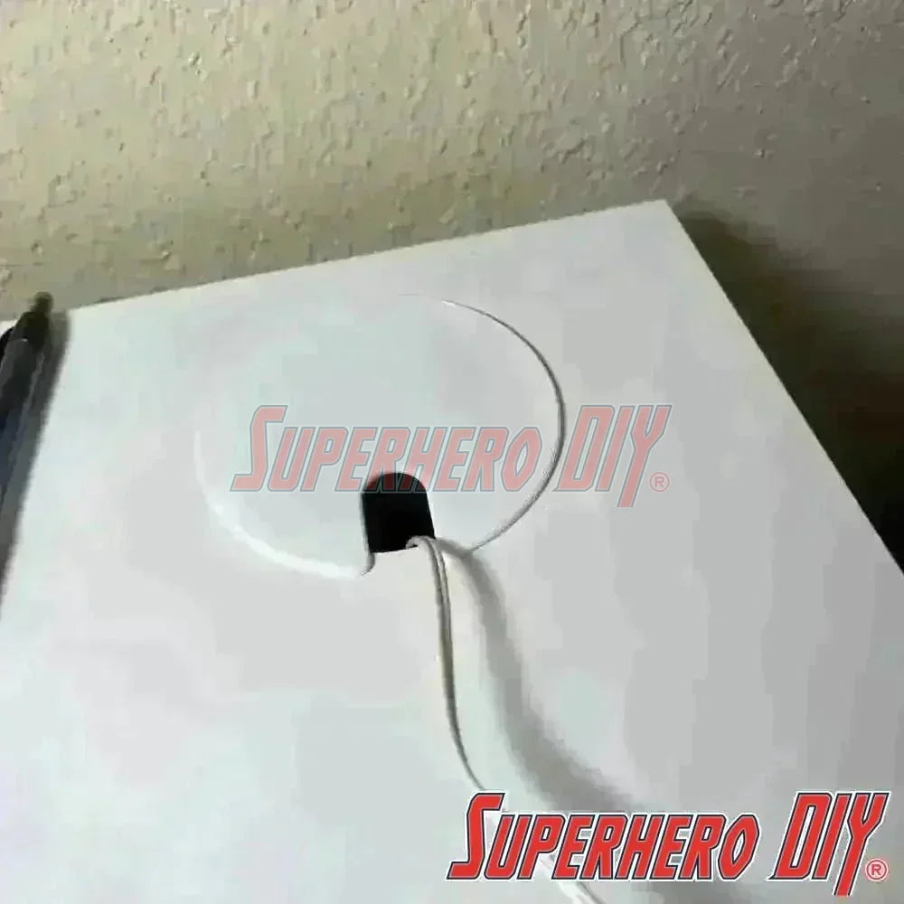 IKEA MICKE desk hole cover in place, concealing a wiring hole on a white desk surface, enhancing cleanliness and organization.