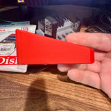 Hand holding a red CFexpress Type B card organizer with 8-slot stepped design on a desk.
