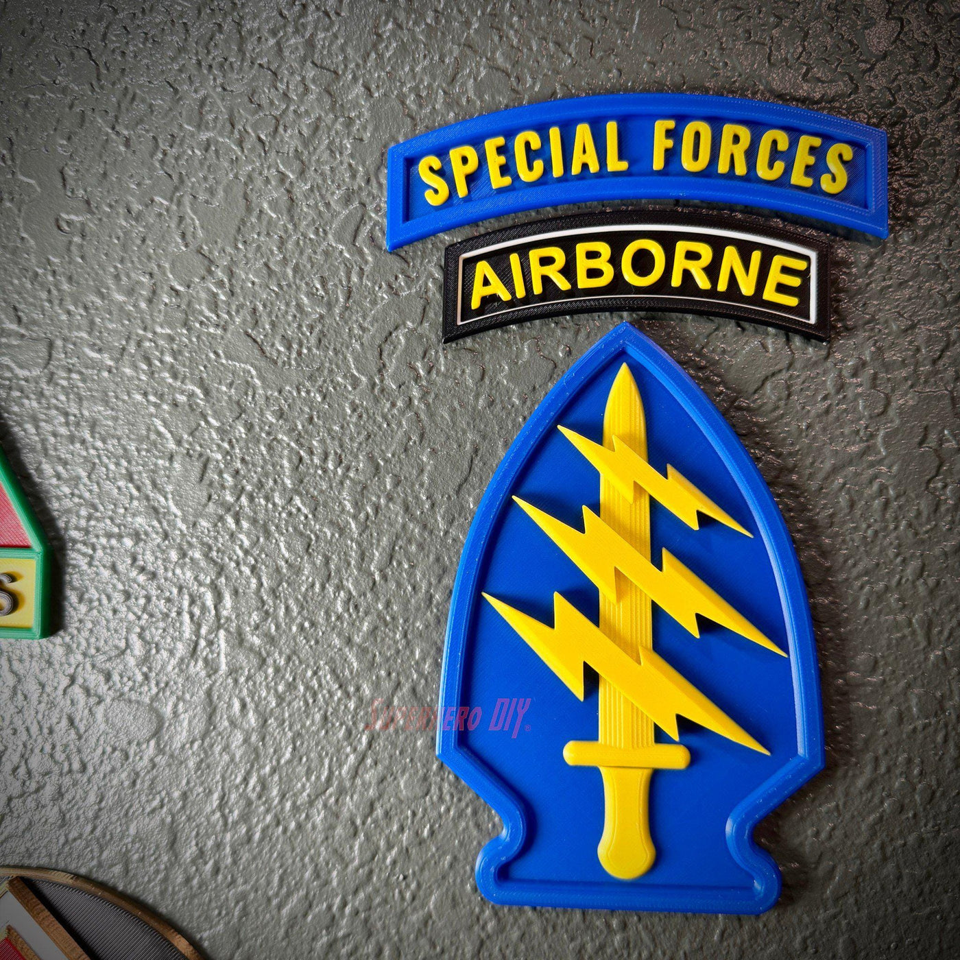 Special Forces display insignia featuring Airborne tab and arrowhead with lightning design on a textured gray background.