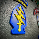 Special Forces display insignia featuring yellow dagger and lightning bolts on blue background.