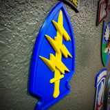 Special Forces display insignia featuring a blue arrowhead with a yellow dagger and lightning bolts.