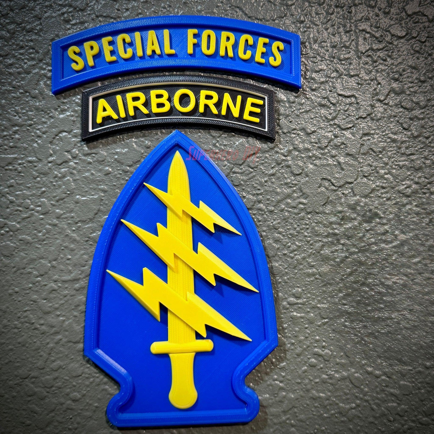 Special Forces display insignia featuring arrowhead and Airborne tab on a textured background.