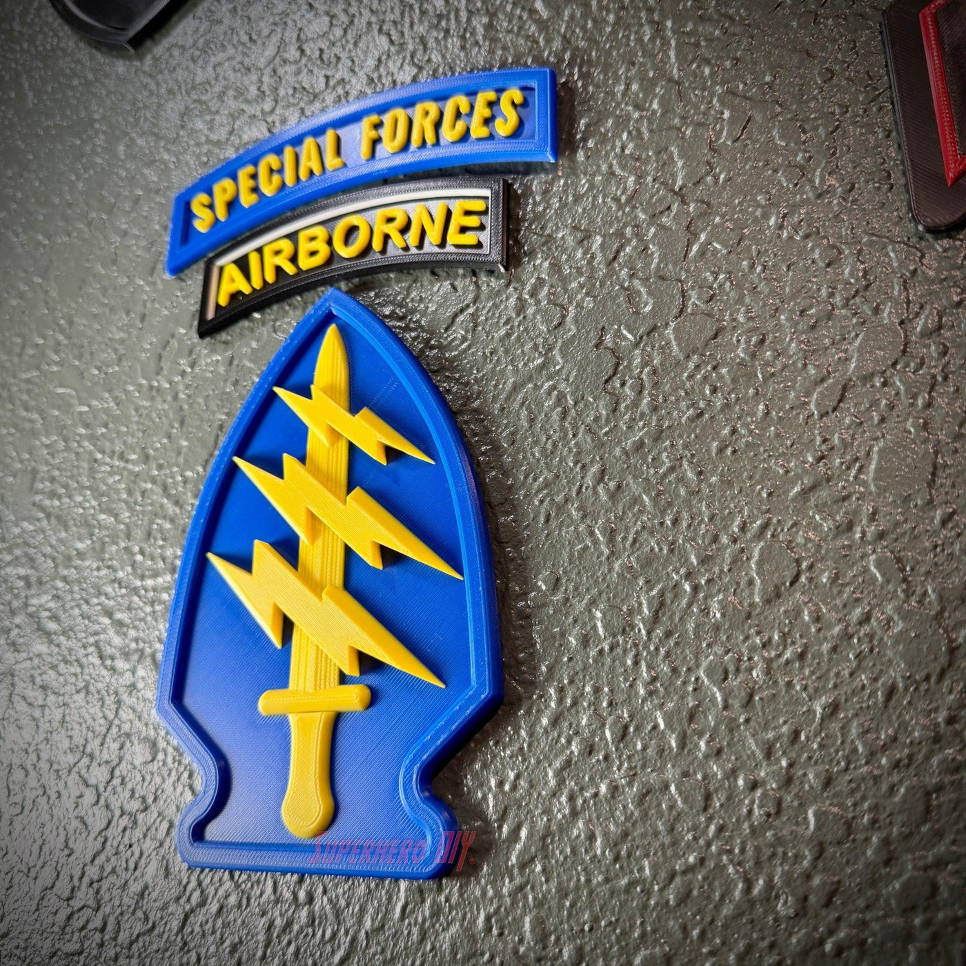 Special Forces display insignia featuring an arrowhead, lightning bolts, and Airborne tab on a textured background.