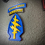 Special Forces display insignia featuring an arrowhead, lightning bolts, and Airborne tab on a textured background.