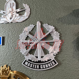 Master Gunner Badge display insignia mounted on a wall, showcasing military achievement and craftsmanship.
